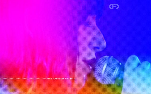 A cantora Karan O em uma foto em close up de perfil e de olhos fechados cantando - a imagem possui um filtro colorido iluminando a imagem com diversas cores - FAROFEIROS.COM.BR