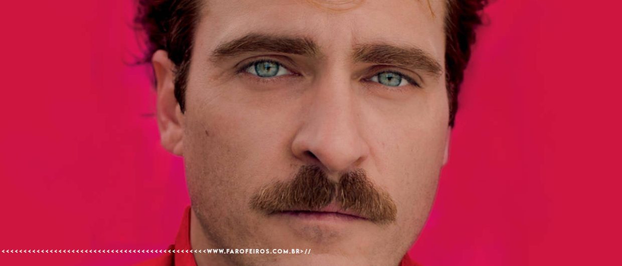 Close up no ator Joaquin Phoenix em frente a um fundo rosa choque em peça promocional do filme Her (2013) - FAROFEIROS.COM.BR