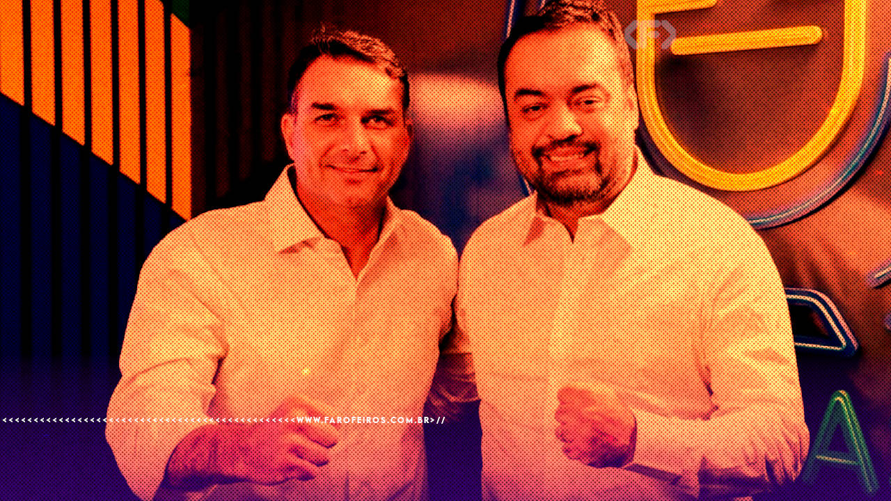 Fotografia com filtro laranja e roxo mostrando Flávio Bolsonaro e Cláudio Castro de camisas sociais claras, sorrindo e posando juntos em um ambiente com letreiro luminoso ao fundo.