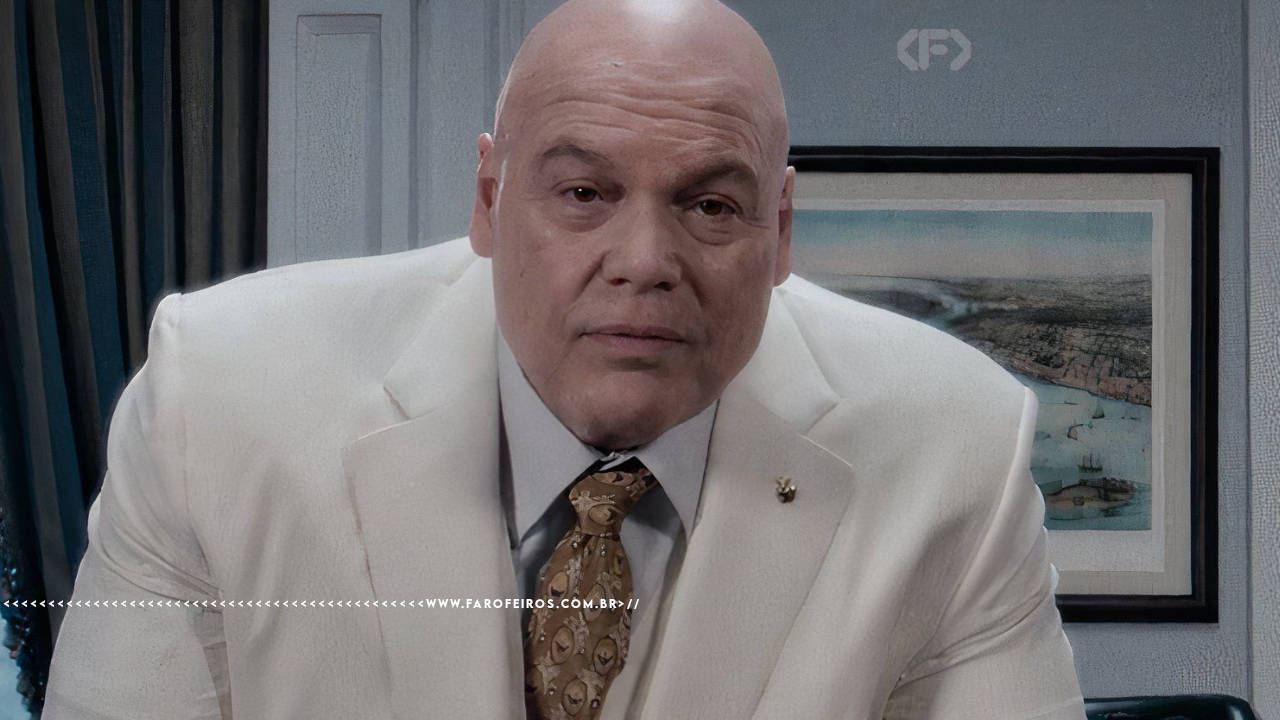 Wilson Fisk, o Rei do Crime, vestindo seu icônico terno branco e gravata dourada, com expressão séria e intimidadora. Captura da série do Demolidor.