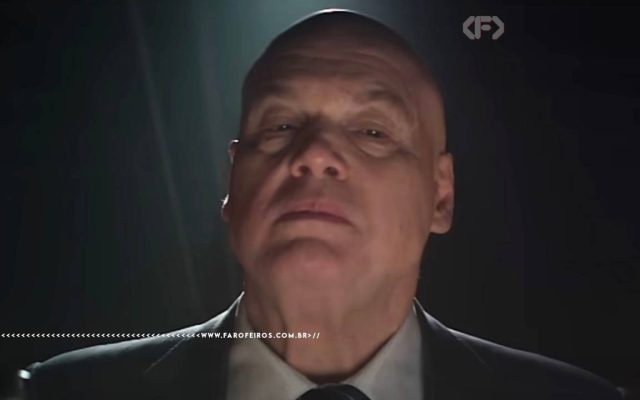 Close dramático de Wilson Fisk em ambiente escuro, com iluminação intensa sobre o rosto, transmitindo uma presença ameaçadora. Captura da série do Demolidor.