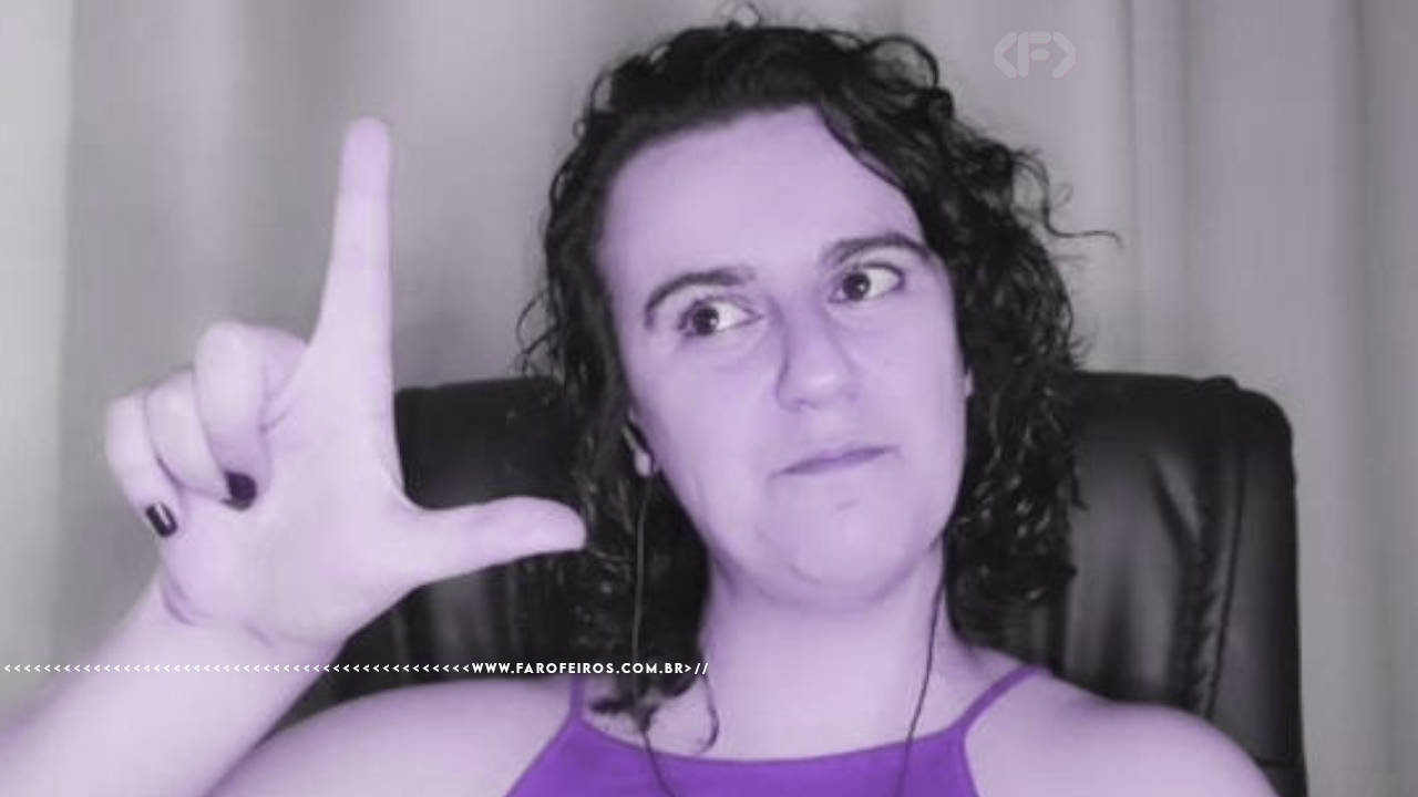 Foto em preto e branco de Paola Costa, com um sorriso discreto fazendo a letra "L" com a mão em referência a Lula com um filtro roxo suave. Na parte inferior, a marca d'água do site www.farofeiros.com.br