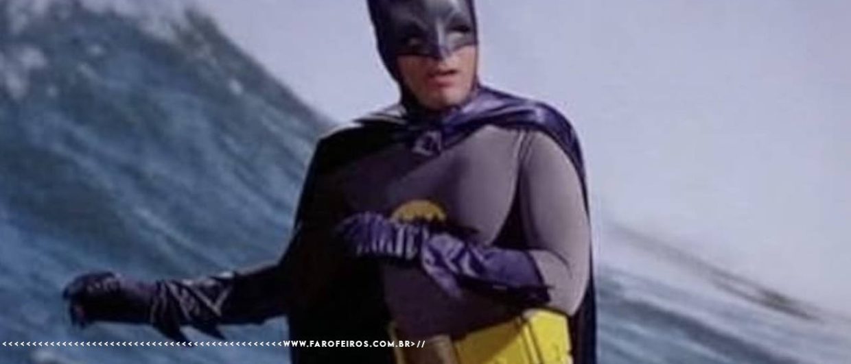 Batman de Adam West surfando de sunga amarela em um corte de cena da cintura para cima e braços jogados para a esquerda.