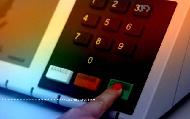 Fotografia focando números da urna eletrônica brasileira com um dedo com unha vermelha apertando o botão de CONFIRMA
